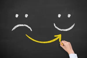 Smiley face replacing a sad face symbolising positive change through coaching