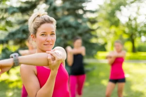 Group exercising outdoors guided by a coach